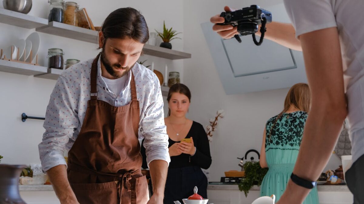 services-02 Chef in a kitchen setting preparing a dish while being photographed for a culinary shoot.
